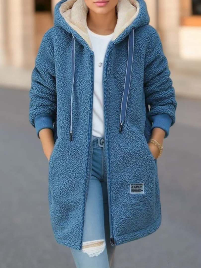 Mannequin souriant portant le sweat à capuche femme Perla, ultra-confortable et élégant pour l'automne-hiver.