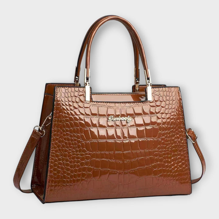 Sac à main brillant motif crocodile texturé, reflets élégants. Idéal pour un style luxe et distingué.