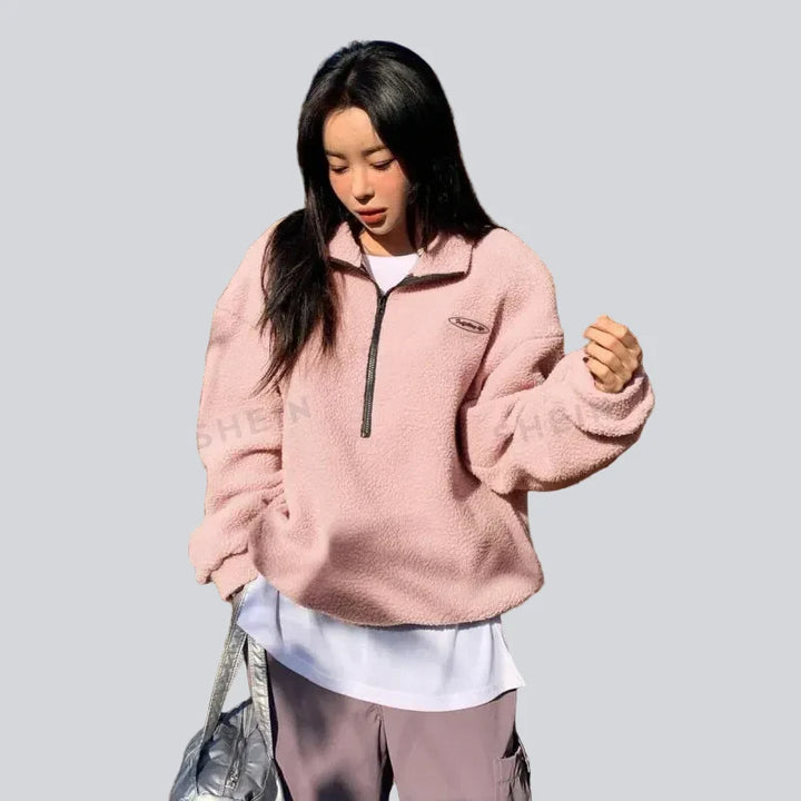 Sweatshirt femme ample à manches longues avec col à cordon, alliant confort décontracté et style urbain.