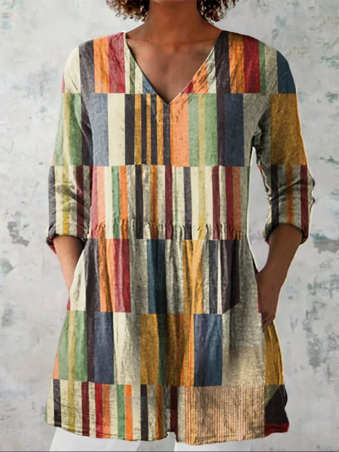Tunique chic femme, rayures graphiques modernes, décolleté en V. Coupe longue et fluide, idéale pour l'automne.