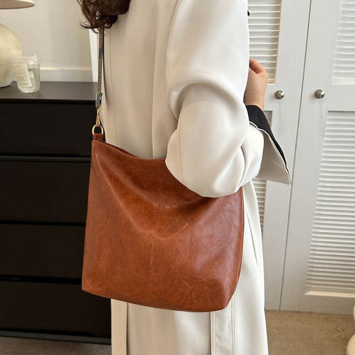 Sac bandoulière Wanda en cuir PU marron, élégant, porté par une femme moderne.