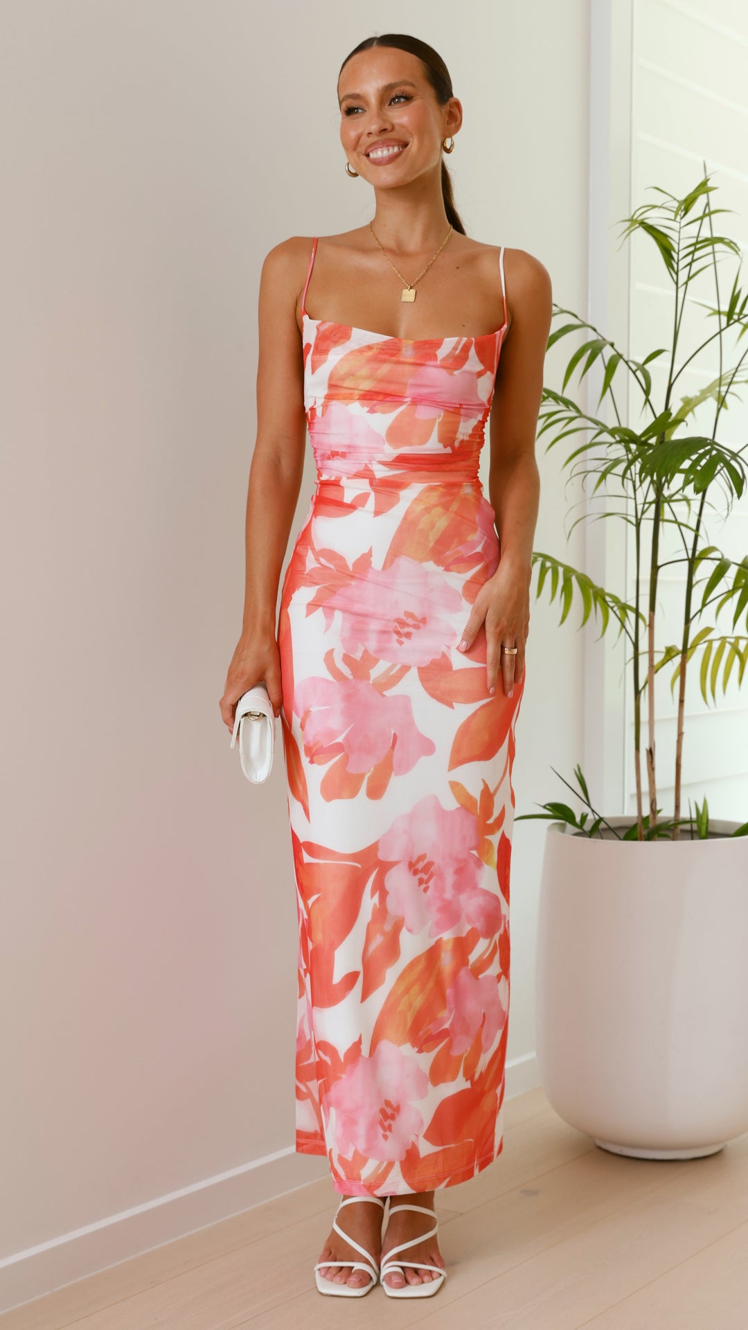 Élégante robe longue rose à fleurs pour femme, bretelles fines et coupe ajustée. Idéale pour événements spéciaux.