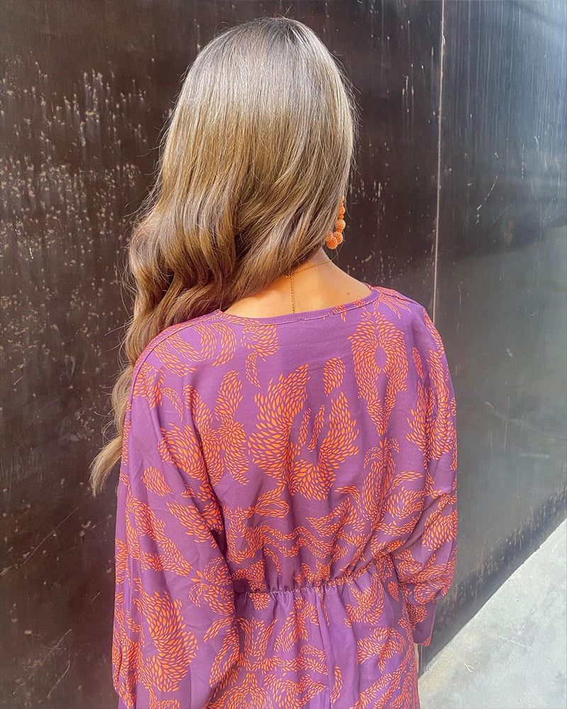 Silhouette élégante en robe midi femme, décolleté V. Tenue de cocktail idéale pour une cérémonie réussie.