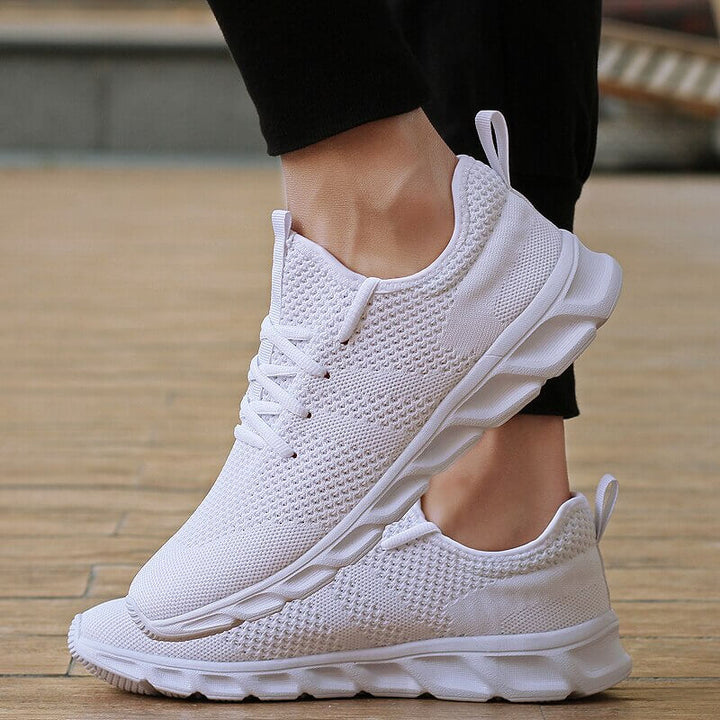 Chaussures athlétiques PureMotion blanches pour hommes, offrant confort et stabilité pour la marche.
