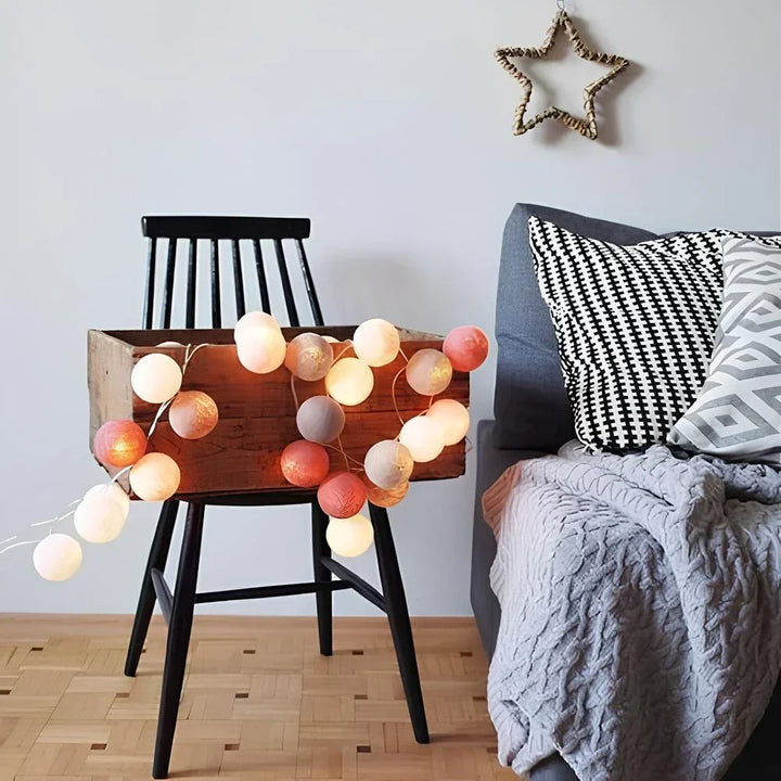 Ambiance cosy assurée avec cette guirlande lumineuse LED en boules de coton naturelles.