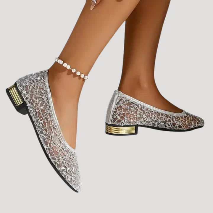 Escarpins à talons hauts pailletés argentés portés par une femme. Chaussures élégantes bout pointu glamour.