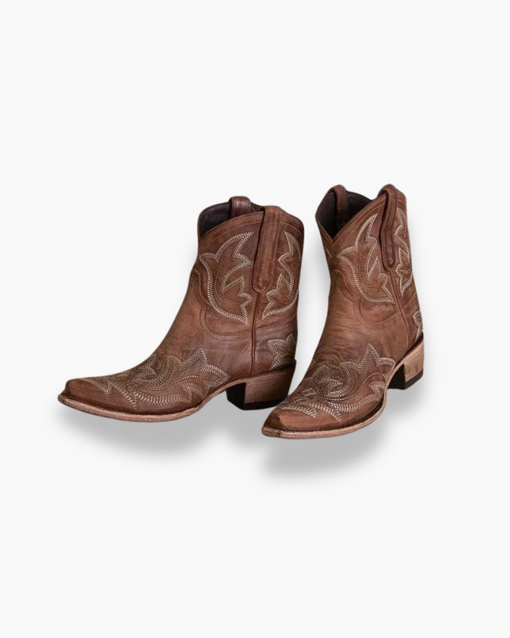 Bottes western élégantes pour femme en cuir marron, broderies détaillées, talon cubain. Style authentique et confort.