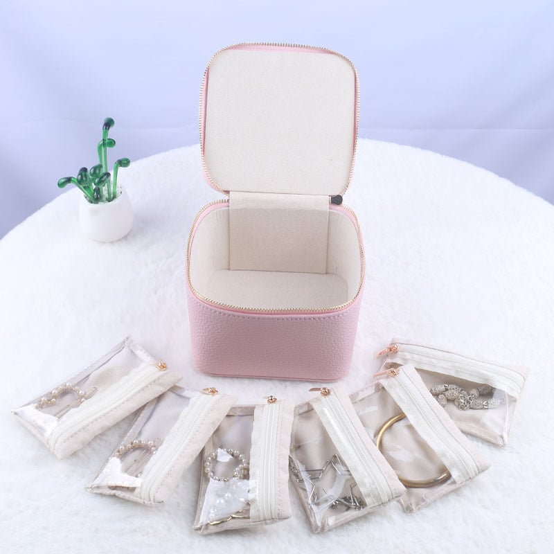 Boîte de rangement de bijoux noire ouverte, montrant les poches zippées pour divers accessoires.