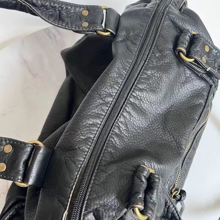 Sac à main femme élégant en cuir noir vintage, parfait pour compléter un style chic et sophistiqué.