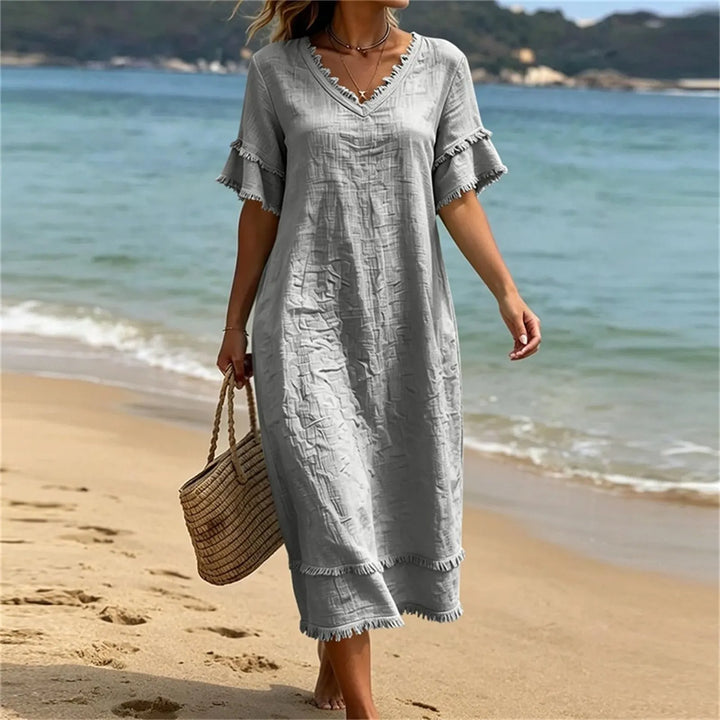 Superbe robe fluide femme bohème avec col V profond et franges. Idéale pour un look estival et printanier décontracté.