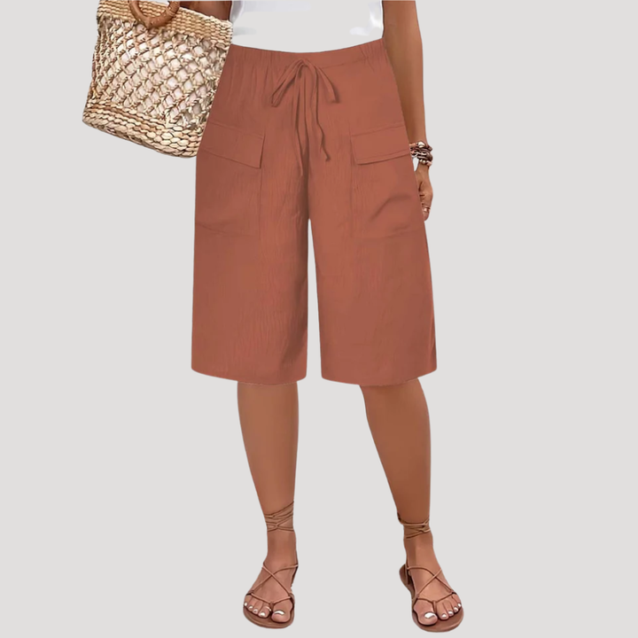 Bermuda femme longue moderne, taille élastique confortable et poches, idéal pour grande taille et look décontracté d'été.