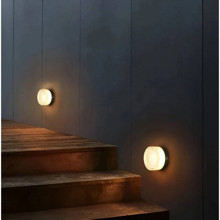 Éclairage d'escalier LED mural rond, design contemporain, lumière d'ambiance et de sécurité.