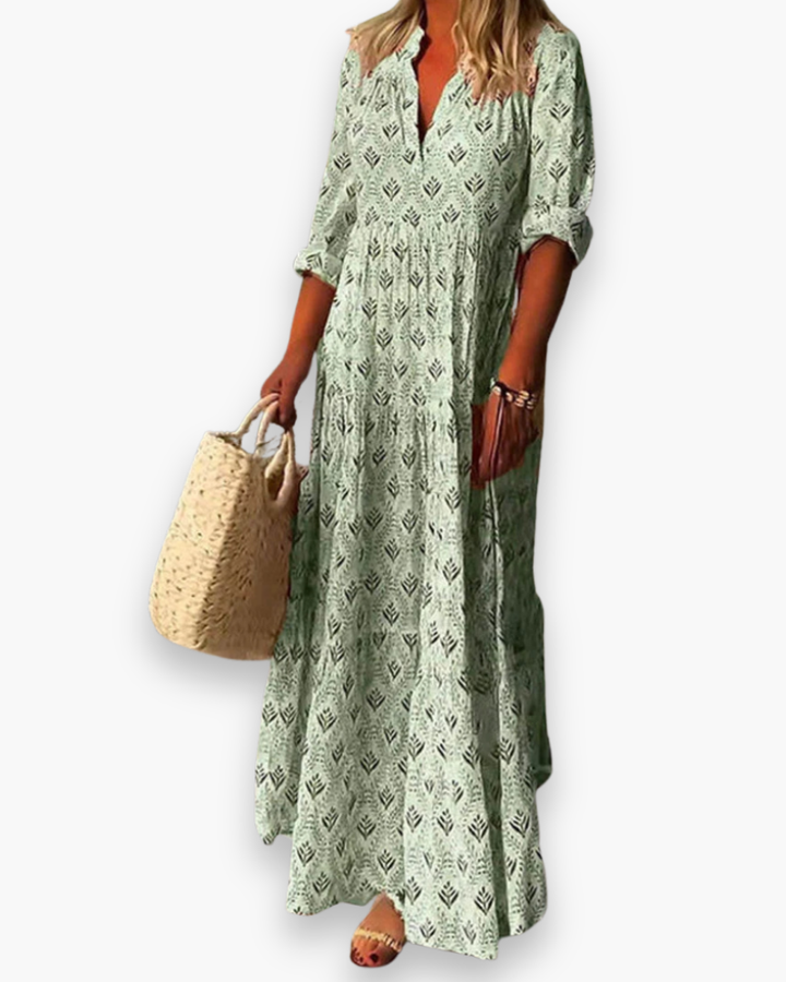 Femme portant une robe longue fluide bohème, motif estival. Tenue décontractée chic pour journées ensoleillées.