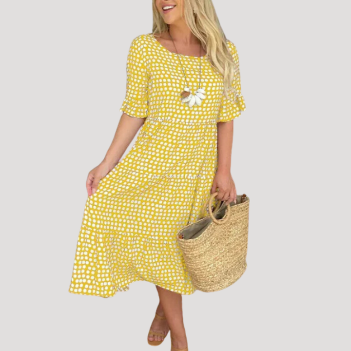 Gros plan sur le tissu fluide et les pois d'une robe midi femme, idéale pour un confort polyvalent en été.
