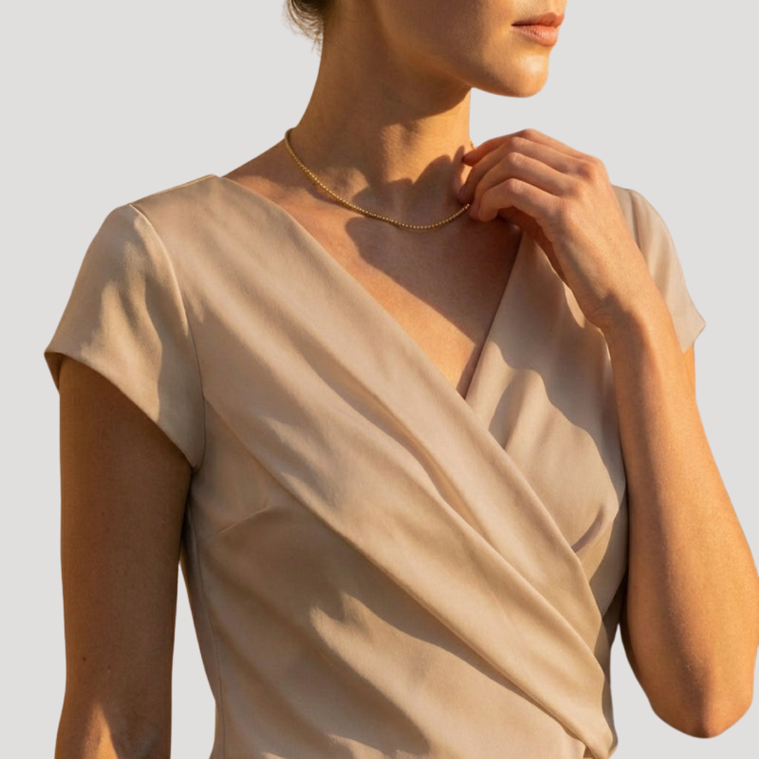 Blouse fluide et féminine avec col V drapé, manches courtes. Un essentiel élégant pour votre garde-robe estivale.