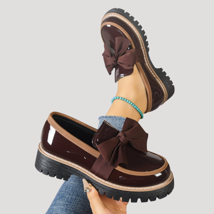 Chaussures mocassins femme vernis à enfiler, avec un grand nœud décoratif, alliant confort et mode.