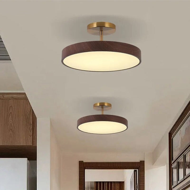 Lampe de plafond Fjell avec abat-jour en bois et détails laiton doré, style nordique épuré.
