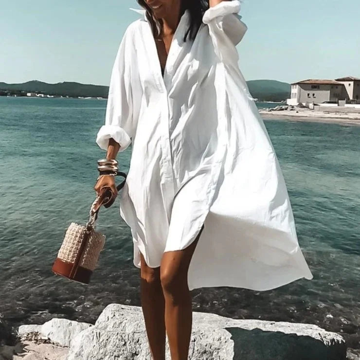 Vue d'ensemble de la robe midi chemise. Robe fluide blanche, élégante et confortable, un essentiel de la mode estivale femme.