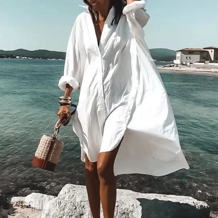 Vue d'ensemble de la robe midi chemise. Robe fluide blanche, élégante et confortable, un essentiel de la mode estivale femme.
