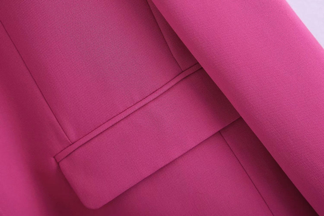 Femme en ensemble rose poudré, blazer et pantalon élégants, style professionnel et tendance.