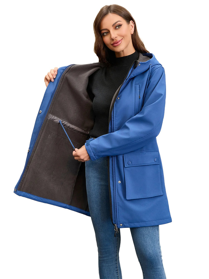 Femme en veste imperméable à capuche, randonnée en montagne. Protection coupe-vent optimale.