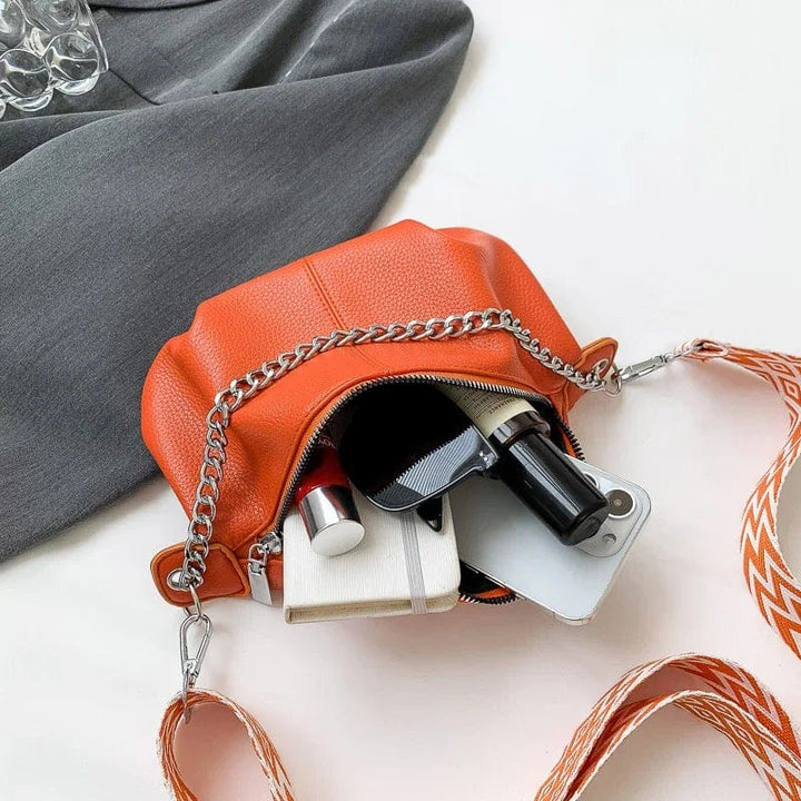 Sac banane orange chic en cuir souple pour femme, un accessoire mode bandoulière moderne.