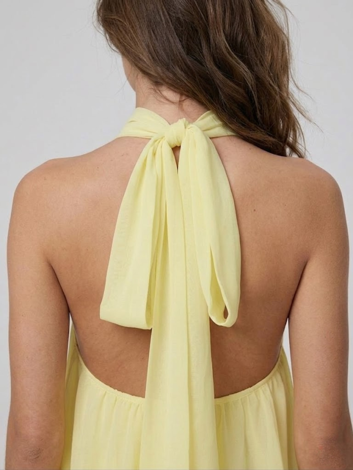 Robe courte femme élégante, dos nu, col halter, style volanté pour soirées d'été ou cocktails.