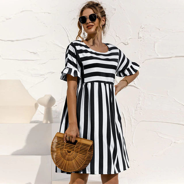 Femme portant une robe mini rayée élégante, parfaite pour un été décontracté.