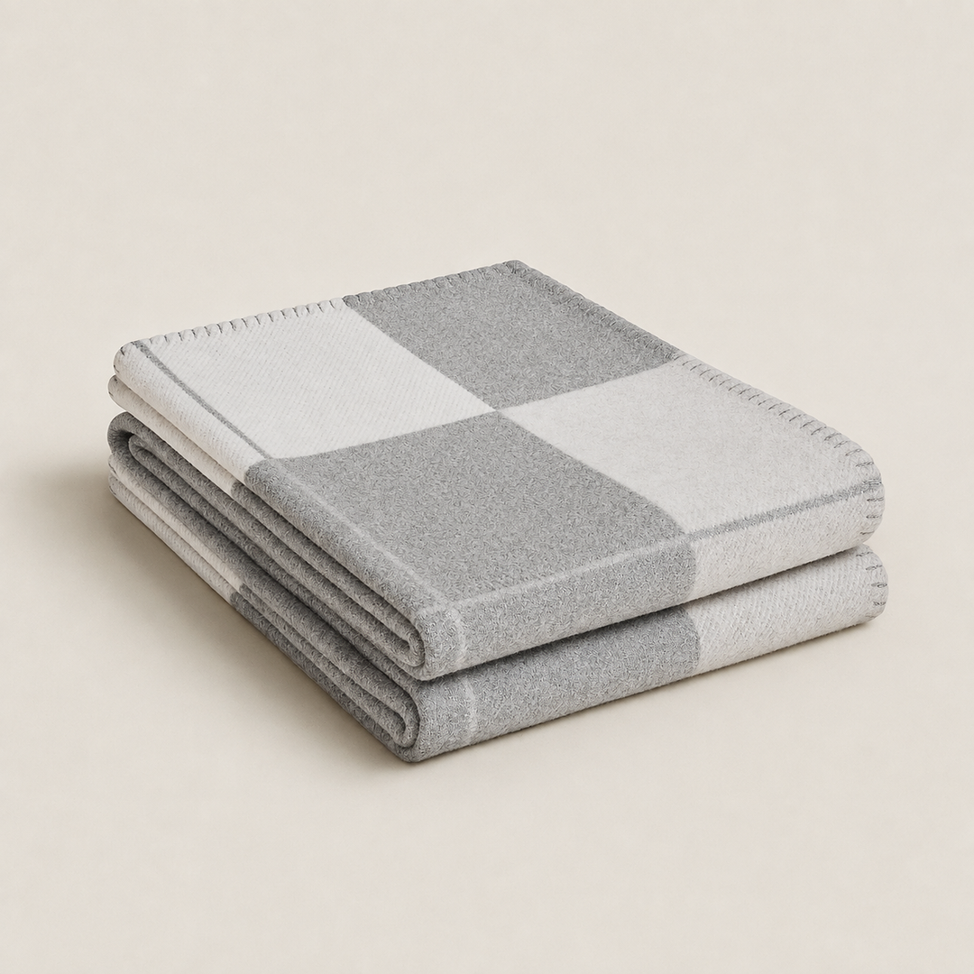 Plaid en laine et cachemire drapé sur un canapé, décorant le salon avec chaleur, confort et luxe.