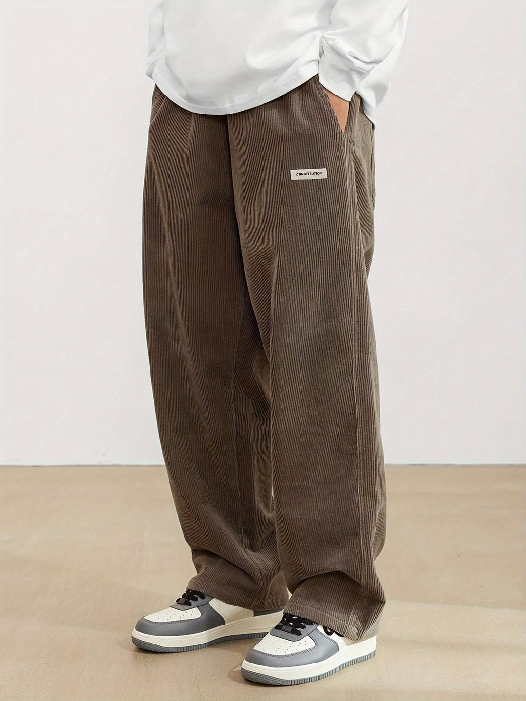Pantalon homme velours côtelé, coupe jambes larges, style rétro décontracté.