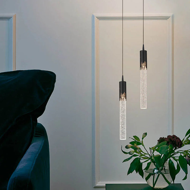 Suspension en verre cylindrique, design moderne, crée une ambiance chaleureuse et stylée.
