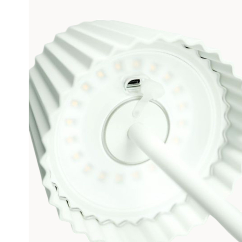 Lampe LED portable LumiPort utilisée en extérieur sur une terrasse, offrant un éclairage sans fil rechargeable USB.
