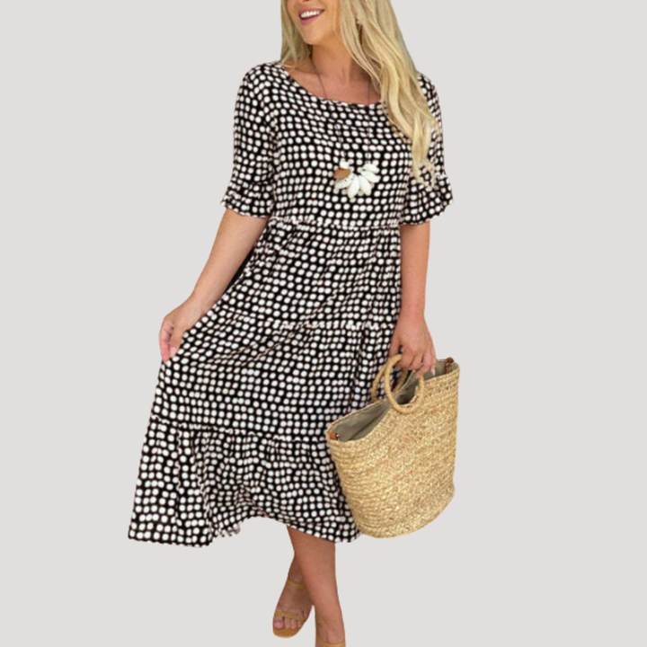 Robe midi fluide femme à pois noirs, manches courtes, pour un look élégant et décontracté d'été.