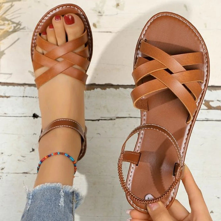 Sandales plates marron confortables pour femmes, avec soutien plantaire et brides croisées, parfaites pour l'été.
