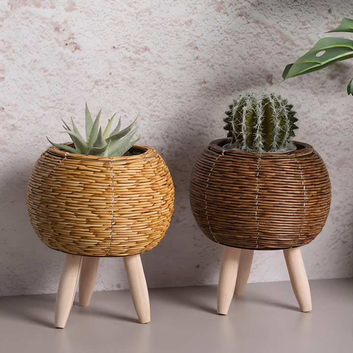 Pot de fleurs décoratif en rotin synthétique avec pieds en bois, pour plantes d'intérieur.