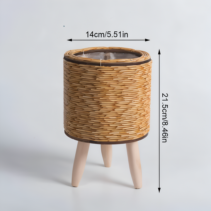 Jardinière tressée en rotin synthétique, pieds en bois clairs, pour plantes d'intérieur et extérieur.