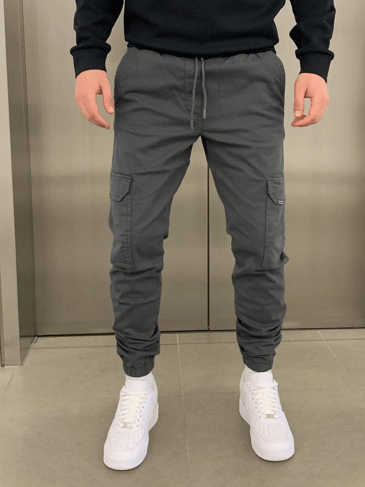Vue de côté d'un pantalon jogger cargo homme, coupe ajustée et poches pratiques pour un look dynamique.