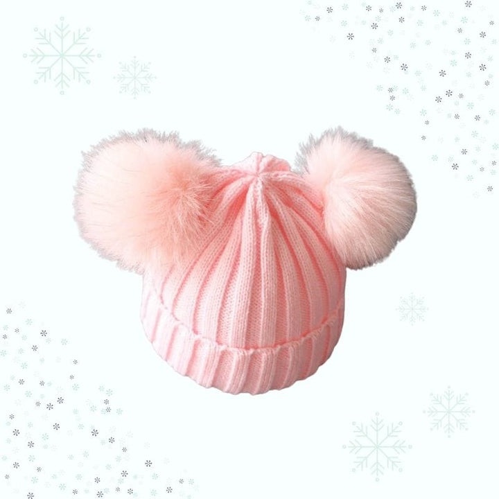 Gros plan sur le pompon du bonnet bébé. Détail charmant de l'ensemble hiver écharpe assortie pour enfant.