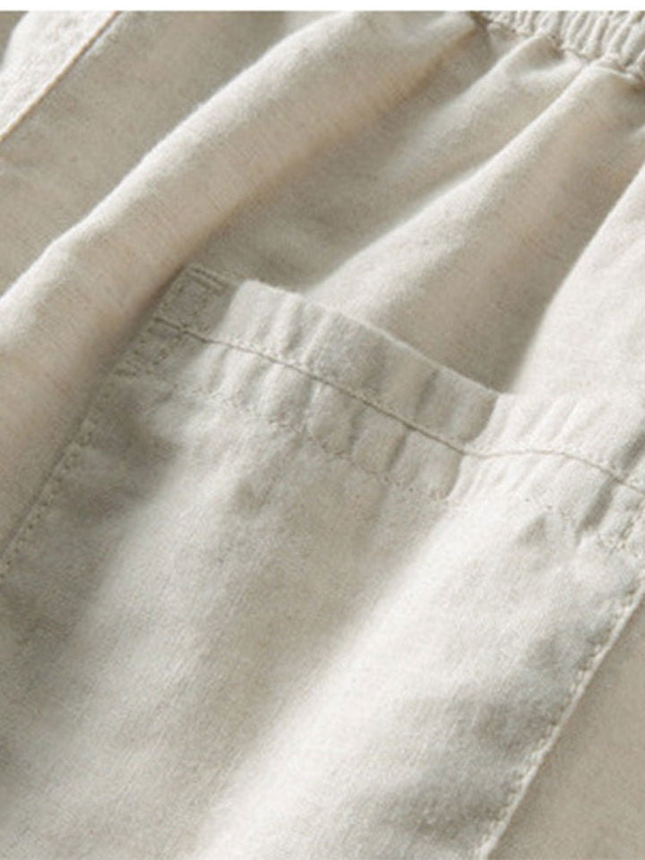 Homme portant l'ensemble été décontracté. Chemise lin manches courtes et pantalon pour un look chic. Tenue confort.