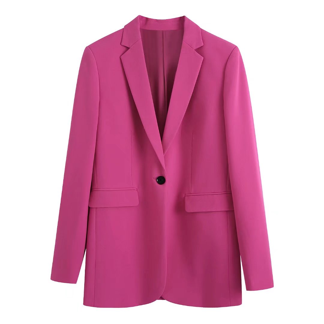 Femme en ensemble blazer pantalon rose poudré, style professionnel moderne et chic.