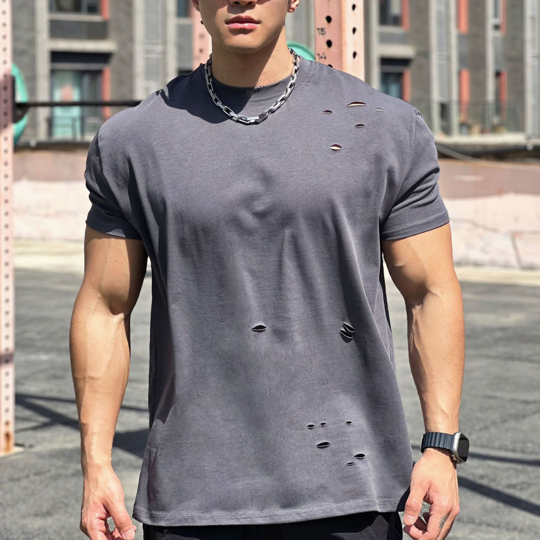 Homme portant t-shirt de sport ample, respirant, assurant une liberté de mouvement optimale.