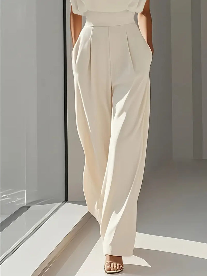 Tenue femme combinaison beige moderne, avec taille haute et jambes droites. Look élégant et polyvalent.