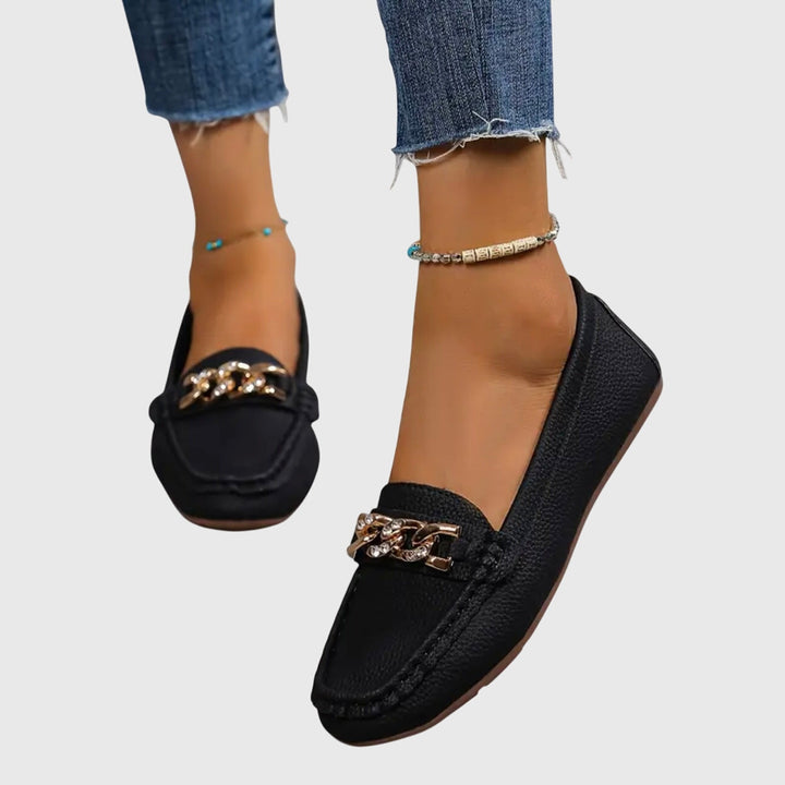 Mocassins femme élégants avec chaîne, bout rond et semelle confortable. Chaussures intemporelles pour un look soigné.