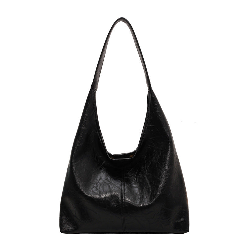 Sac à main noir en cuir vegan avec bandoulière réglable et pochette amovible.