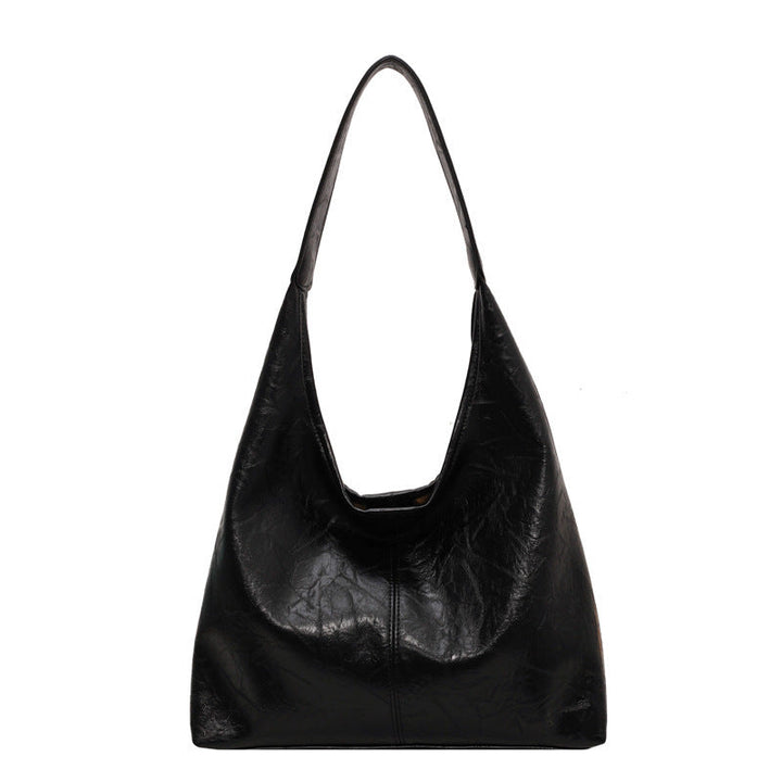 Sac à main noir en cuir vegan avec bandoulière réglable et pochette amovible.