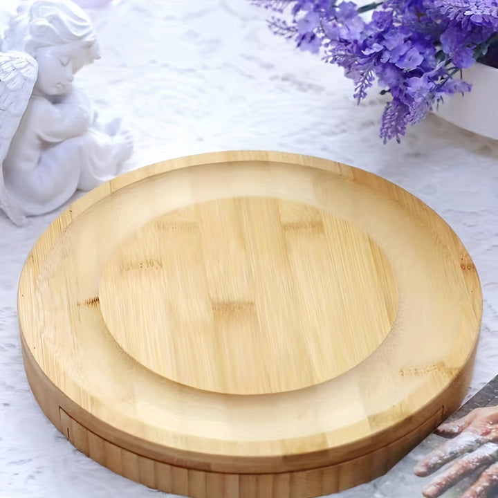 Détail de la planche à fromage en bambou. Surface lisse avec rainure et tiroir contenant les couteaux de service.