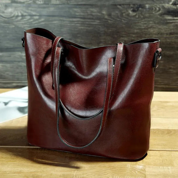 Sac élégant femme en cuir véritable couleur vin rouge. Bandoulière vintage, accessoire mode durable et sophistiqué.