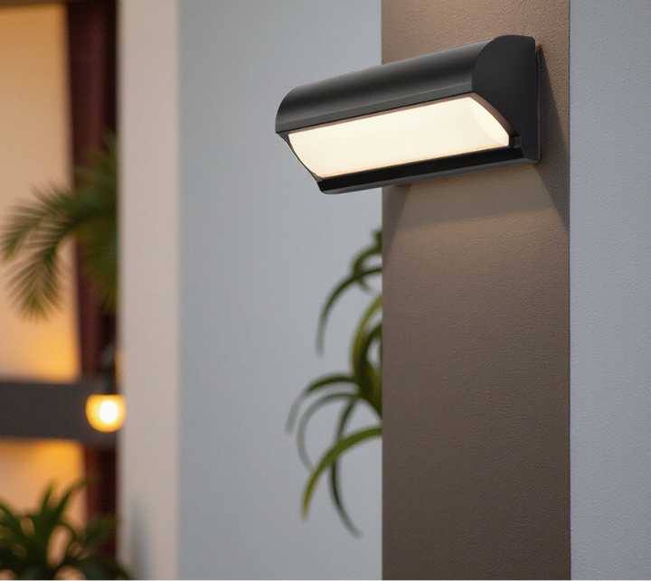 Lampe murale LED noire fixée sur façade. Éclairage extérieur moderne et économe pour jardin et terrasse.