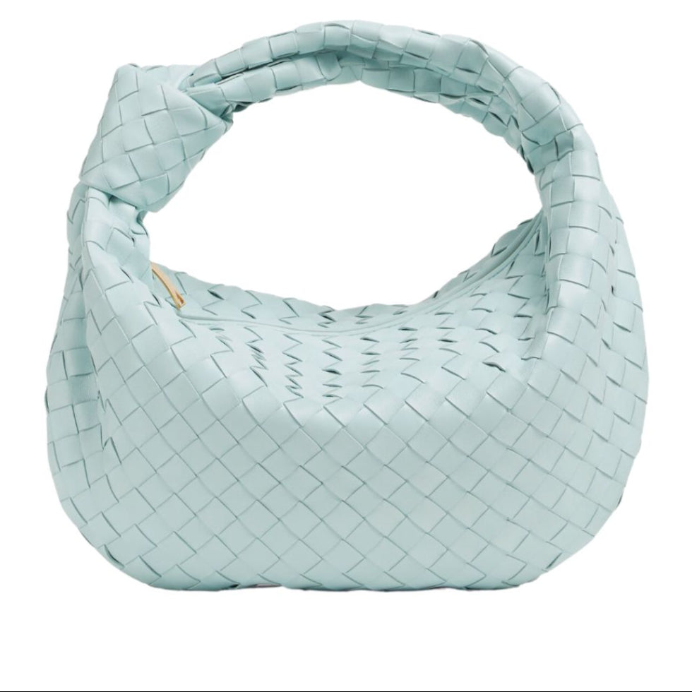 Détail du tressage sophistiqué d'un mini sac à main en simili-cuir, très chic et tendance.