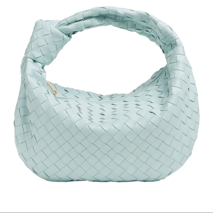 Détail du tressage sophistiqué d'un mini sac à main en simili-cuir, très chic et tendance.